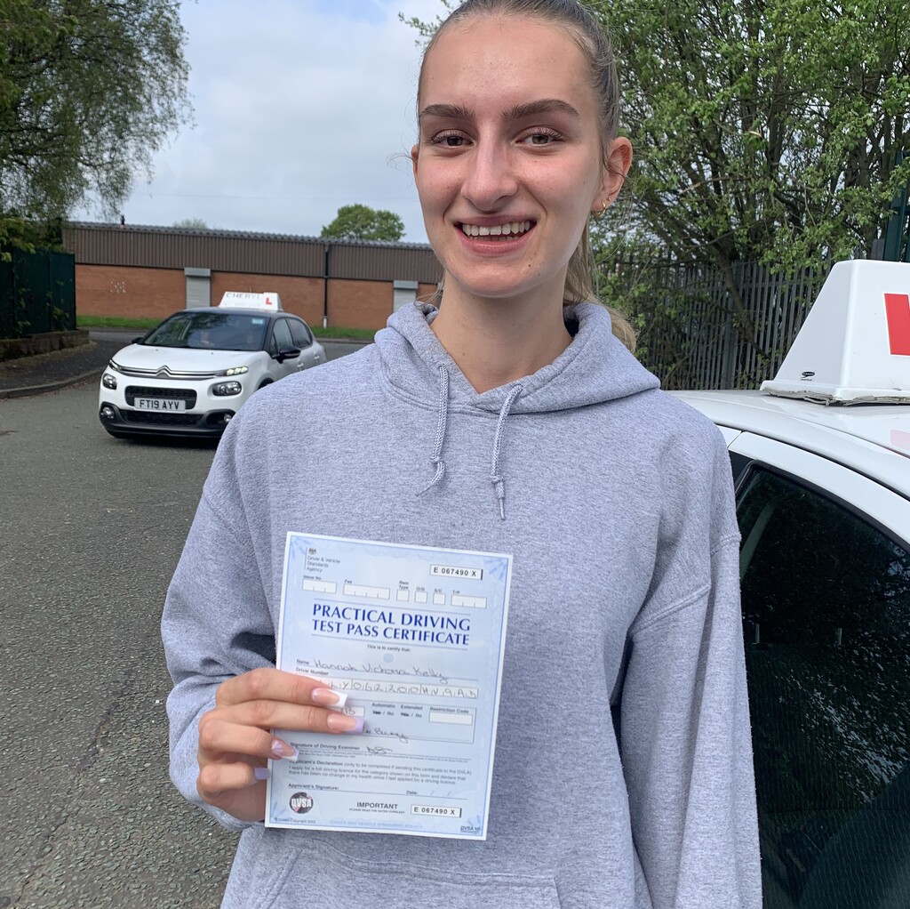 Learner holding a practical driving test pass certificate.