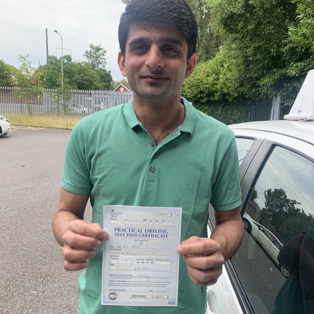 Learner posing with their driving test pass certificate.