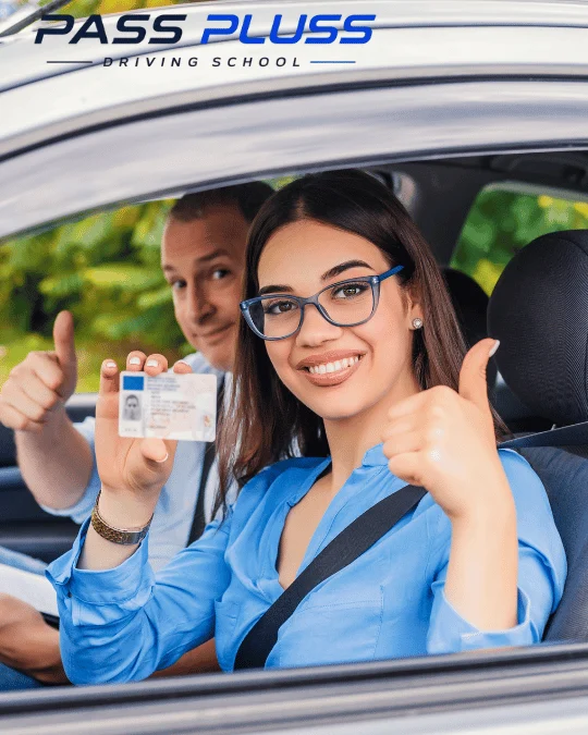 Pass Plus Driving School learner smiling in the driver seat while holding a driving licence